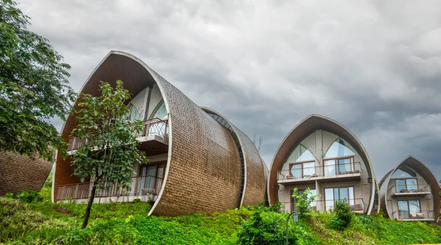 Ark Lake Resort’s curved, shingle-clad villas on a green hillside under a cloudy sky